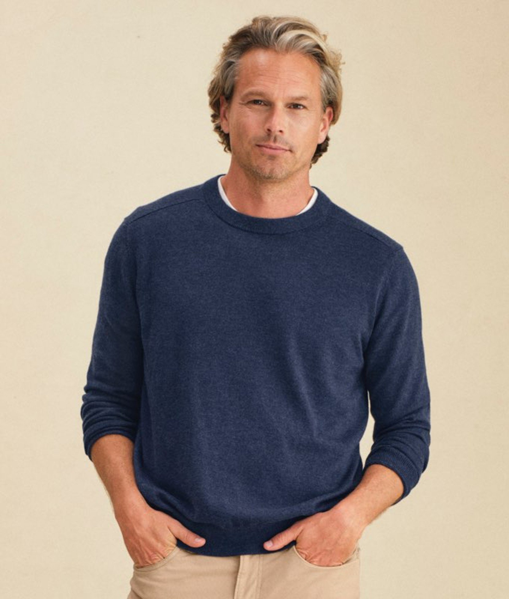 Navy men’s sweater worn by a model standing. 