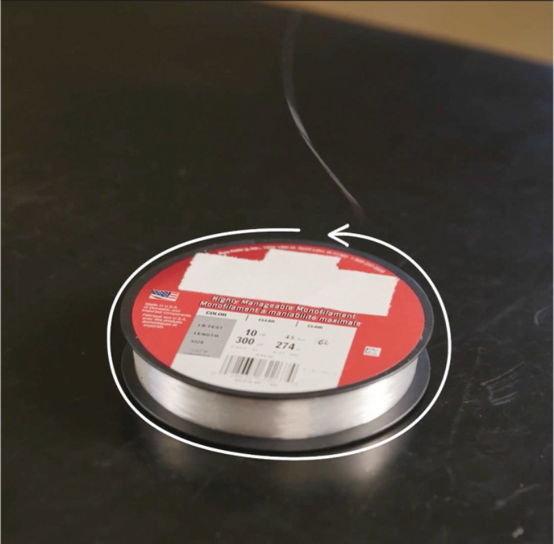 A spool of fishing with specifications 0.030 inches, 300 psi, and 274 feet overlaid by a arrow pointing counter clockwise.