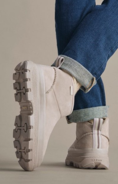 White high-top boots paired with cuffed blue jeans in a studio setting.