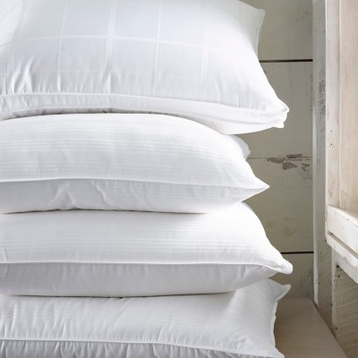 A stack of four white plush pillows.