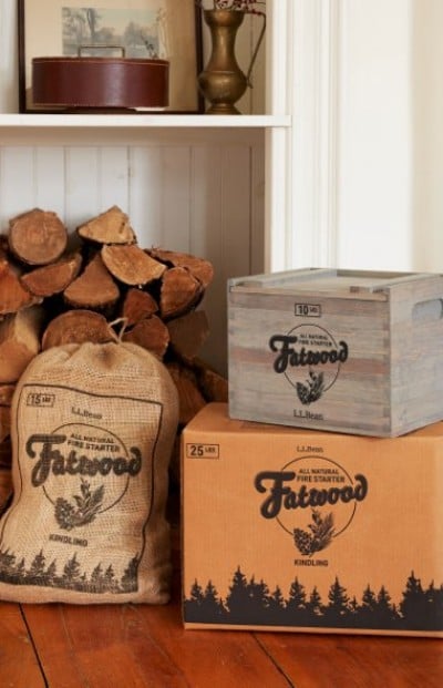 Decorative wooden storage boxes of fatwood beside stacked firewood on a hardwood floor.