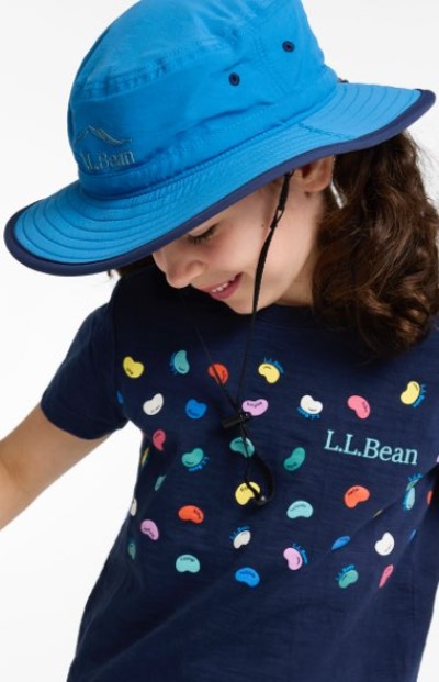 Child wearing a blue sun hat and a navy shirt printed with colorful bean-shaped graphics and an “L.L.Bean” logo.