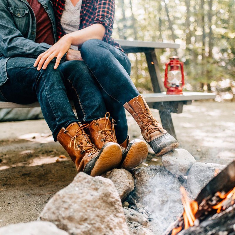 A couple in L.L.Bean Boots by the campfire.
