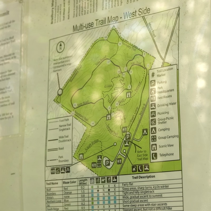 Trail map showing various routes, landmarks, and amenities with a legend detailing trail colors, lengths, and descriptions.