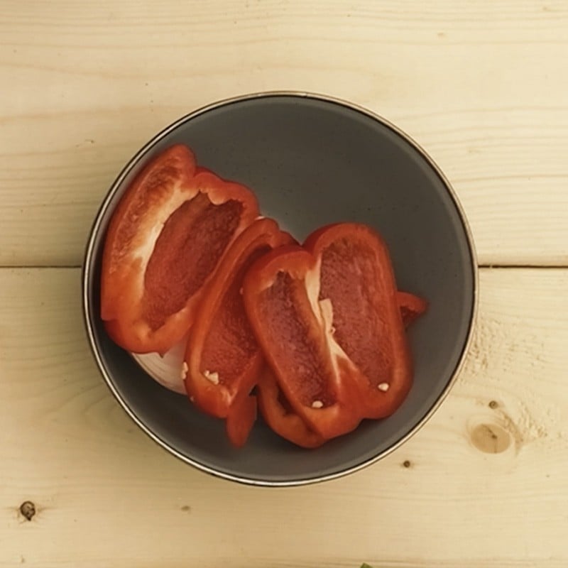 A camp bowl with a cut red pepper in it.