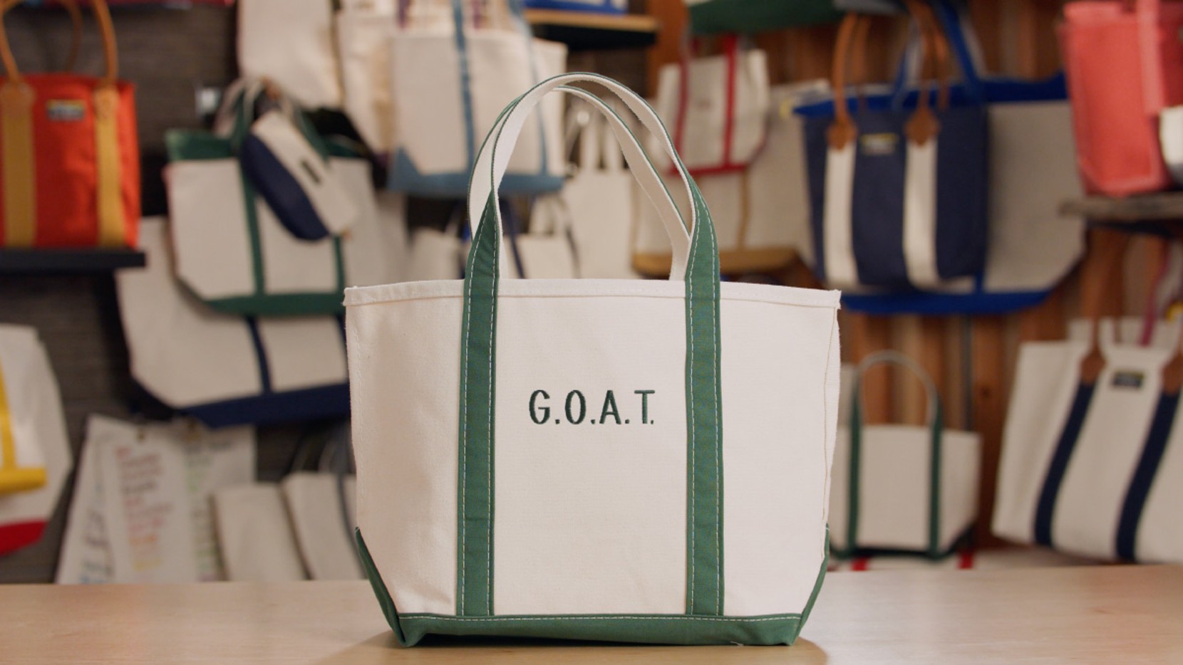 A Boat & Tote with green handles and a green monogram - G.O.A.T.