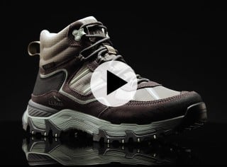 Close up of a brown hiking boot with rugged sole, reflective strips, and L L Bean branding on the side and play video icon.