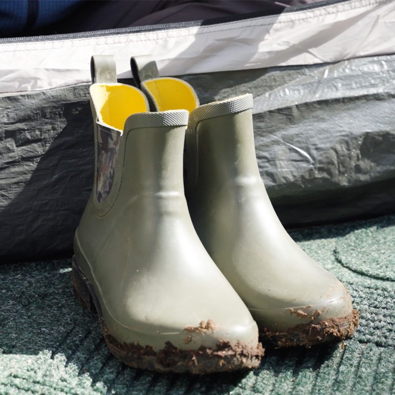 A pair of muddy wellies on a L L Bean waterhog mat, suggesting a recent outdoor adventure.