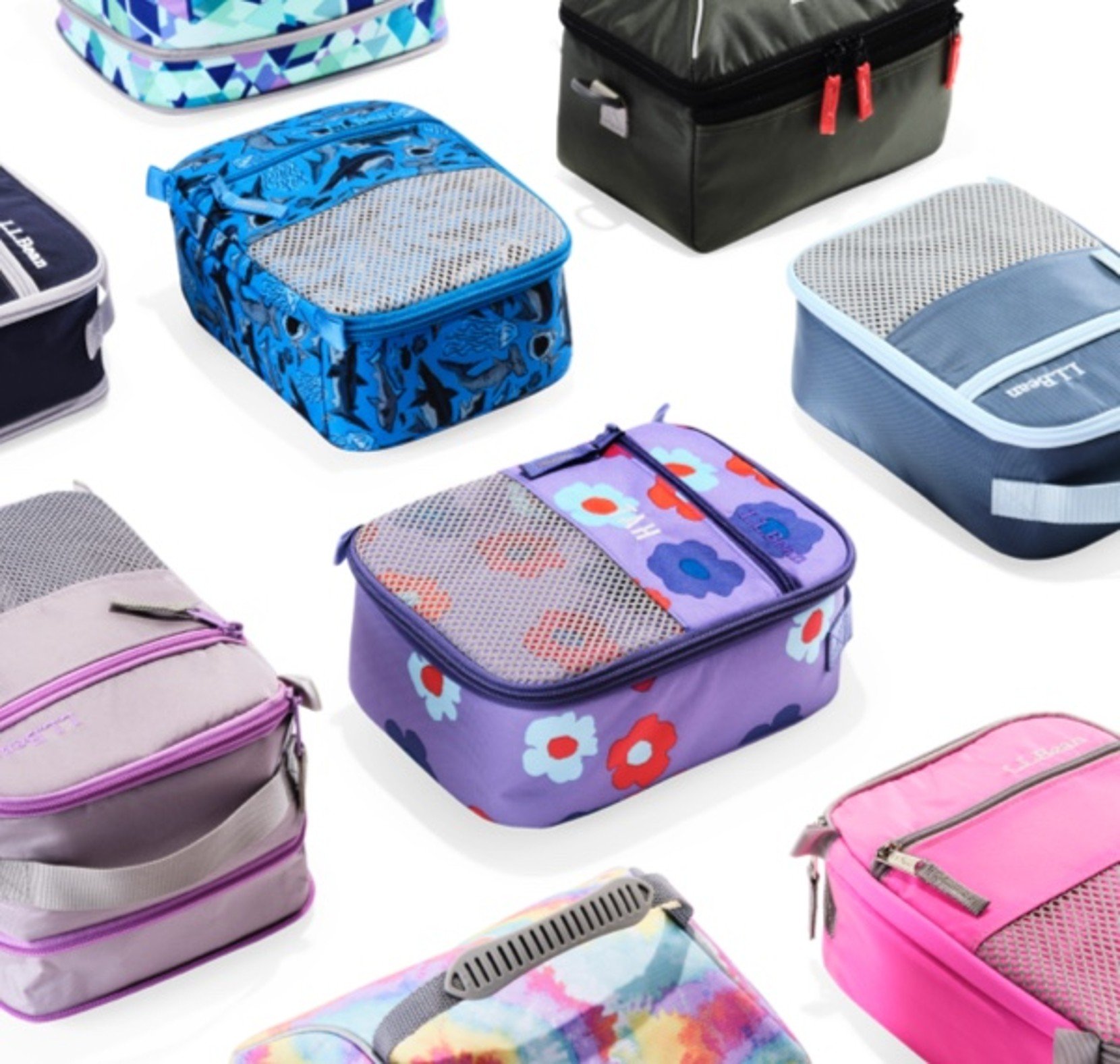 Assorted colorful lunch boxes with fun patterns arranged on a white background.